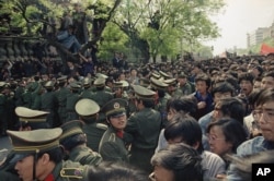 Sinh viên biểu tình ẩu đả với cảnh sát trong khi họ cố phá vỡ hàng rào bảo vệ để tiến vào diễu hành ở Thiên An Môn, Bắc Kinh, 27/4/1989.