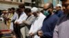 A man wears a protective mask as a preventive measure amid coronavirus fears, as he attends Friday prayers with others in Karachi, Pakistan, March 13, 2020. 