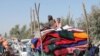 Afghan families leave their houses after fighting between the Afghan military and Taliban insurgents in Helmand province, southern of Afghanistan, Tuesday, Oct. 13, 2020. (AP Photo/Abdul Khaliq)