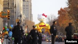 Police walk along Central Park West as the Hello Kitty balloon waits for the start of the 86th Macy's Thanksgiving Day Parade in New York, November 22, 2012. 